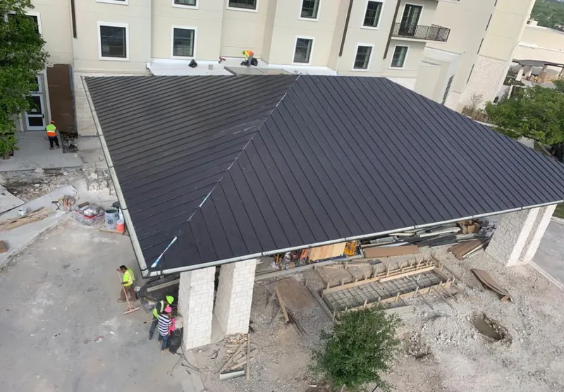 Metal roofing installation team working on a commercial building in Mayfield